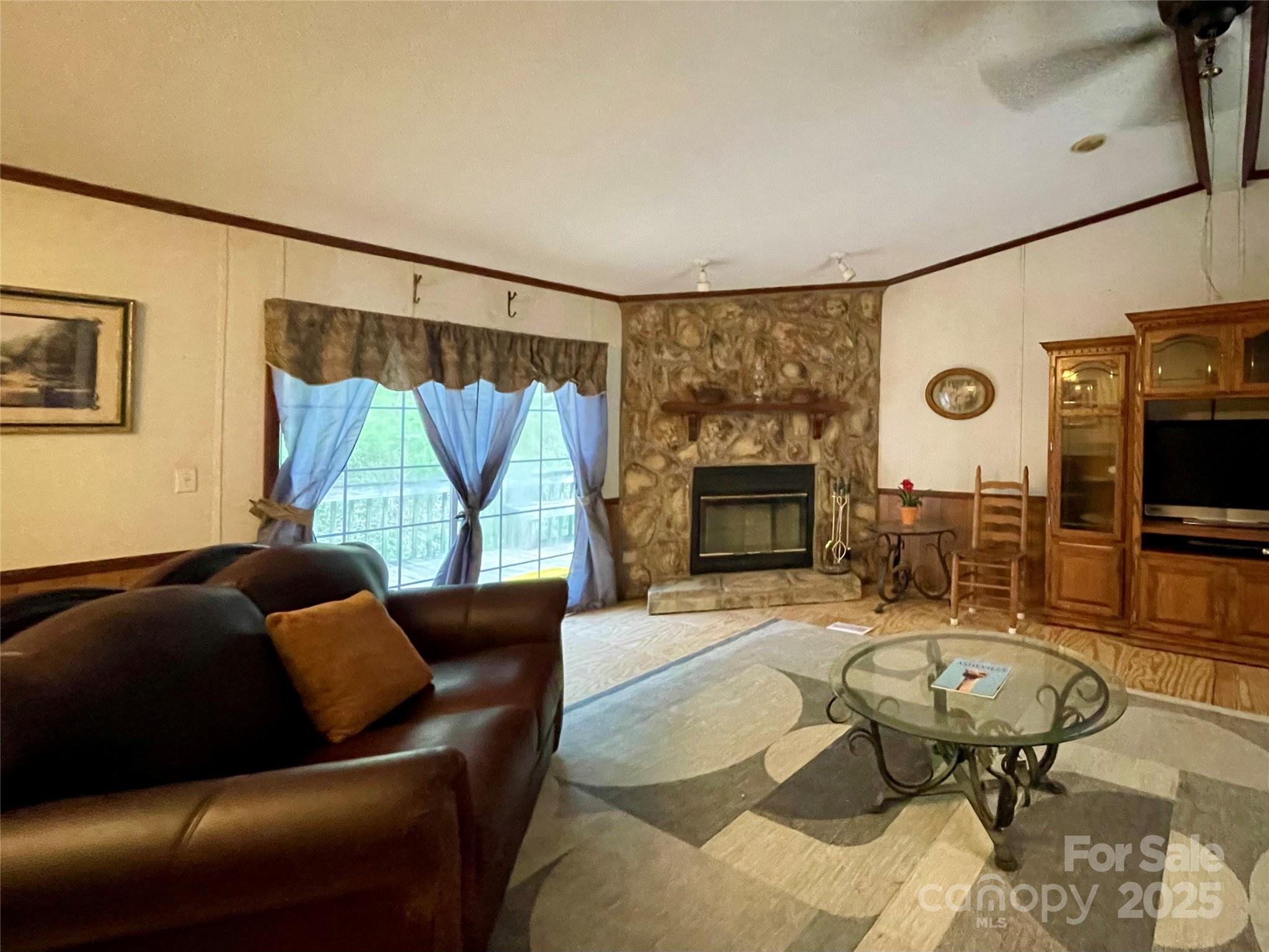 784 Fred Holcombe Road Mars Hill, NC 28754 - Photo 17 of 35 a living room with furniture and a flat screen tv