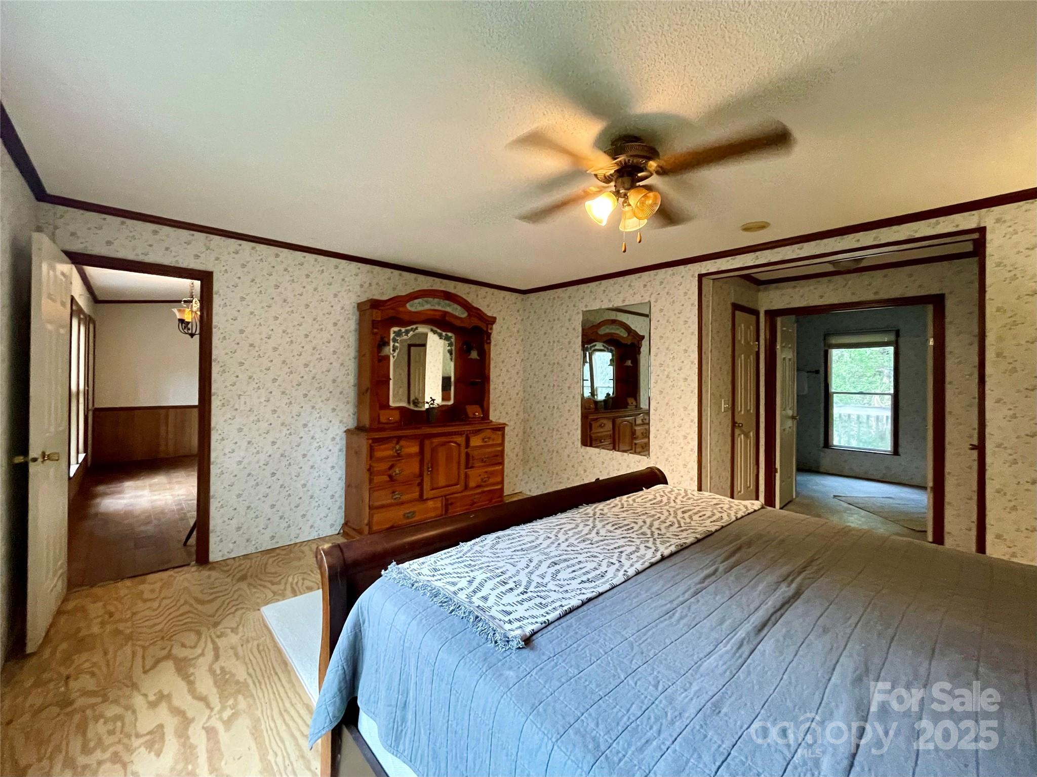 784 Fred Holcombe Road Mars Hill, NC 28754 - Photo 30 of 35 a bedroom with a large bed and a chandelier