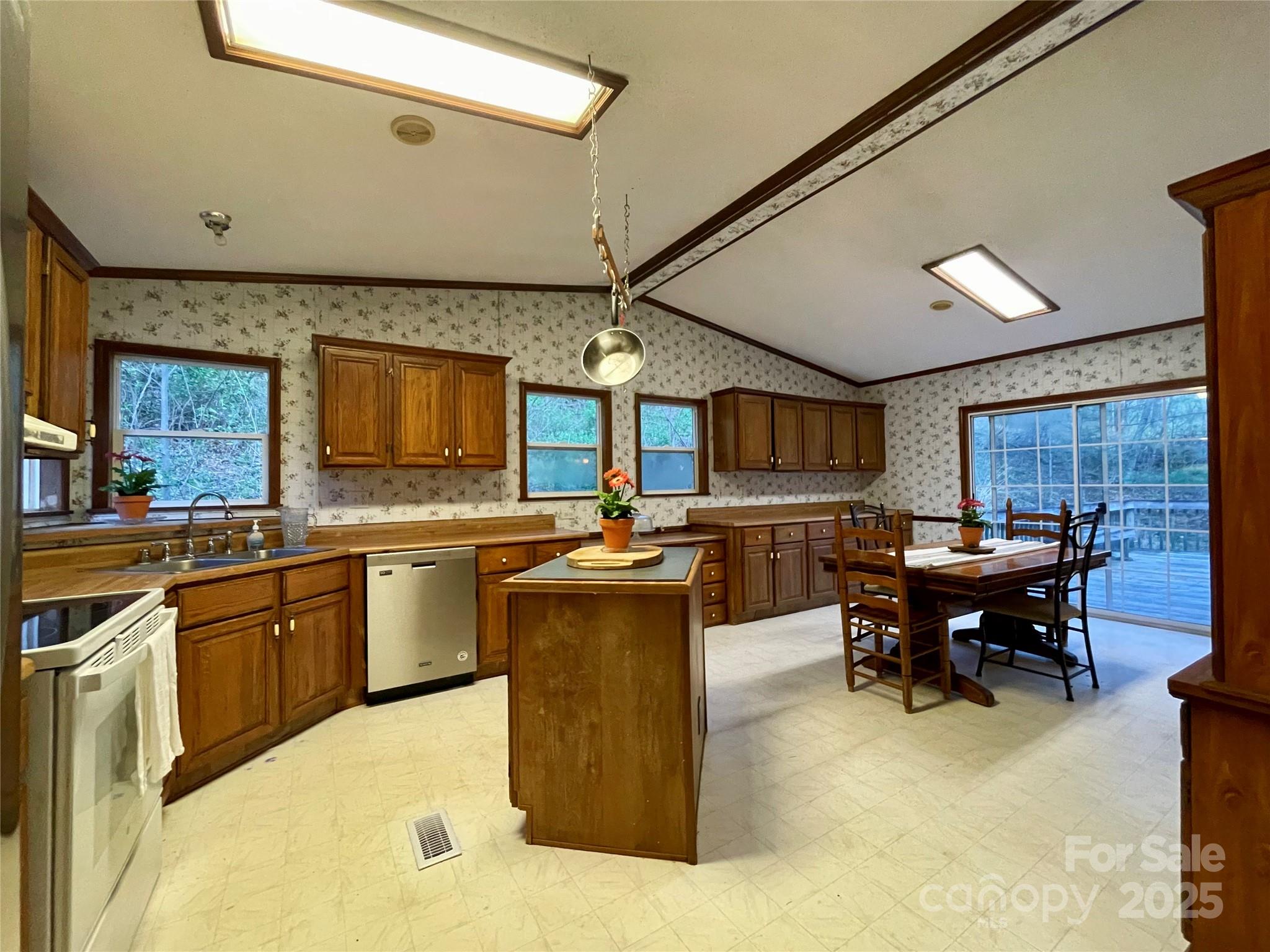 784 Fred Holcombe Road Mars Hill, NC 28754 - Photo 10 of 35 a kitchen with a table chairs sink and a stove top oven