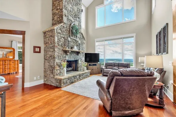 a living room with furniture a floor to ceiling window and a flat screen tv