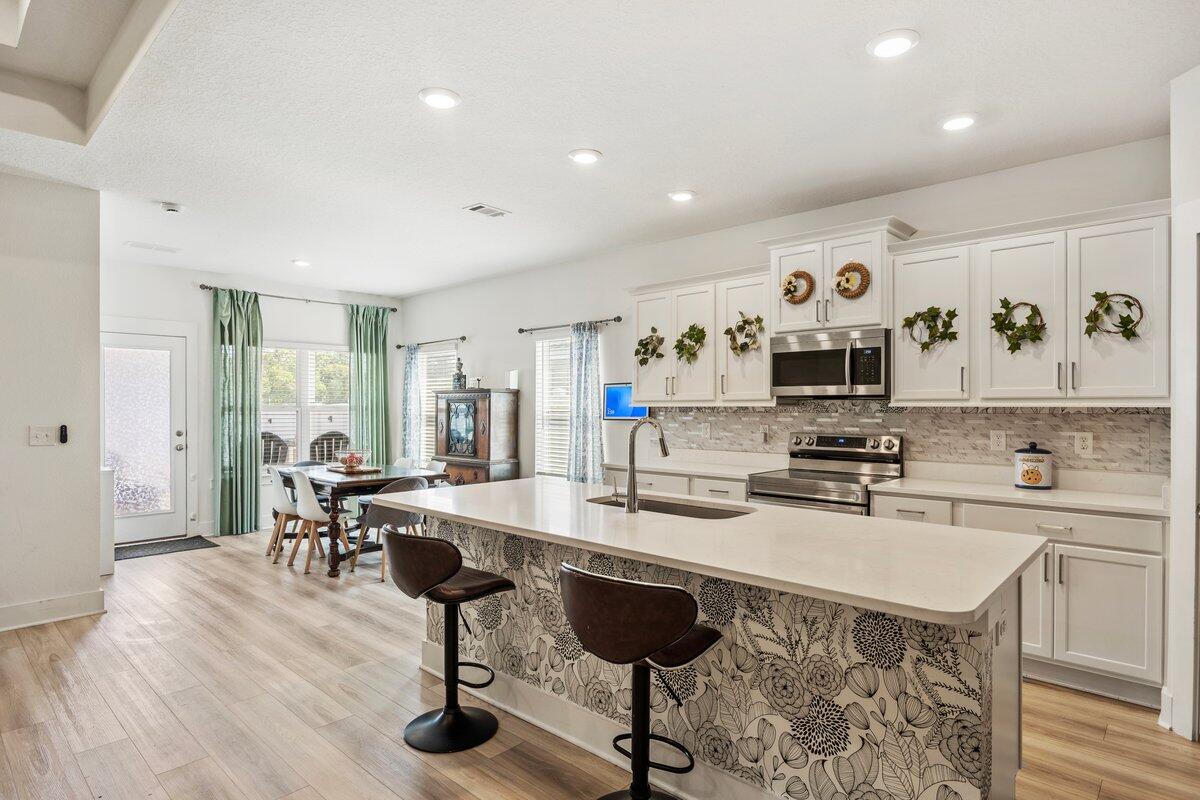 211 Lyla Lane Crestview, FL 32539 - Photo 8 of 38 a kitchen with stainless steel appliances kitchen island granite countertop a sink and cabinets