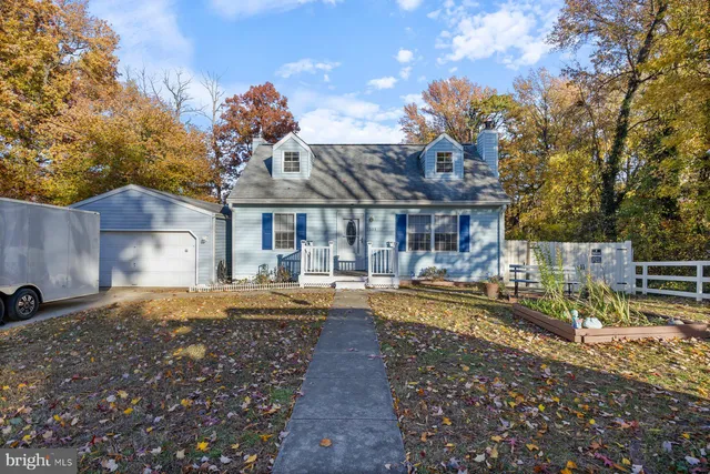 a front view of a house with a yard garden and outdoor seating