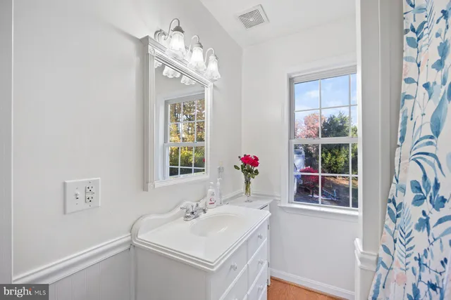 a bathroom with a sink vanity and a mirror
