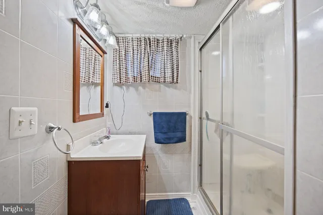 a bathroom with a sink and mirror with shower