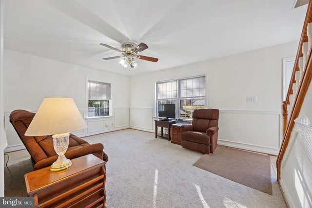 a living room with furniture a ceiling fan and a window