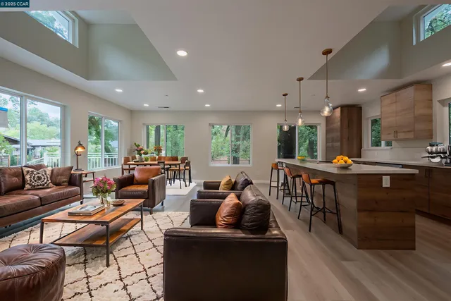 a large kitchen with stainless steel appliances a large counter top a refrigerator and a sink