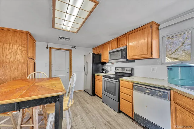 a kitchen with stainless steel appliances granite countertop a stove a sink dishwasher and a refrigerator