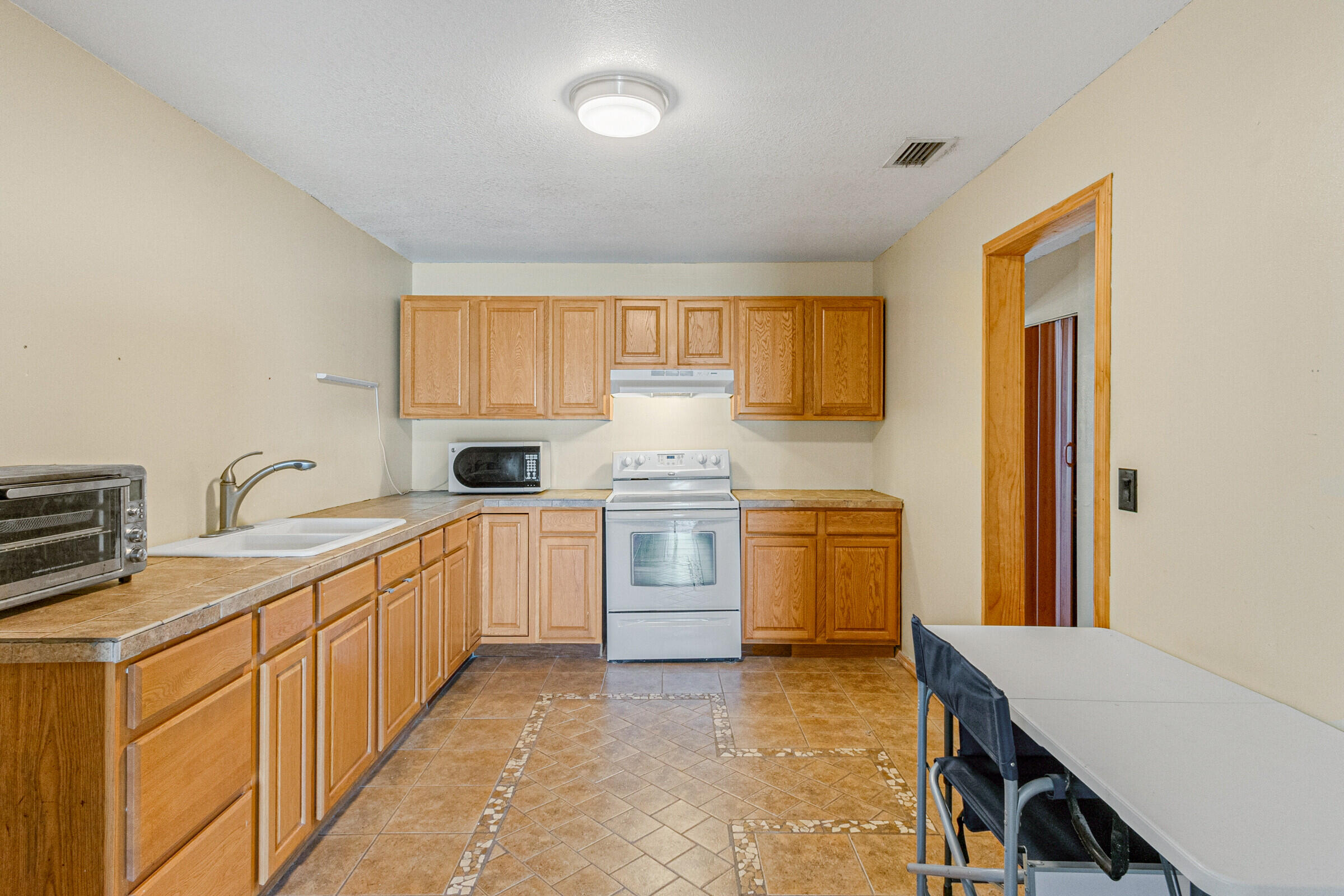 542 Sylvia Road Melbourne, FL 32904 - Photo 30 of 37 a kitchen with a stove top oven sink and cabinets
