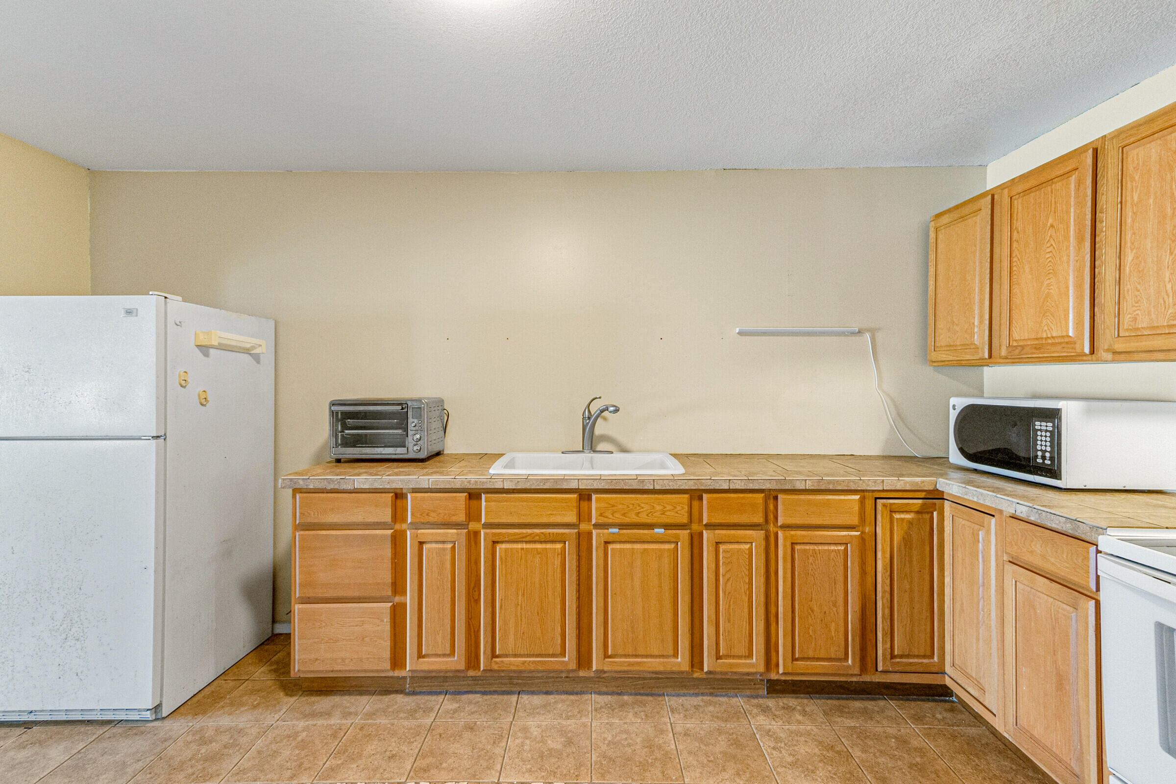 542 Sylvia Road Melbourne, FL 32904 - Photo 32 of 37 a kitchen with stainless steel appliances a white refrigerator a sink and a stove