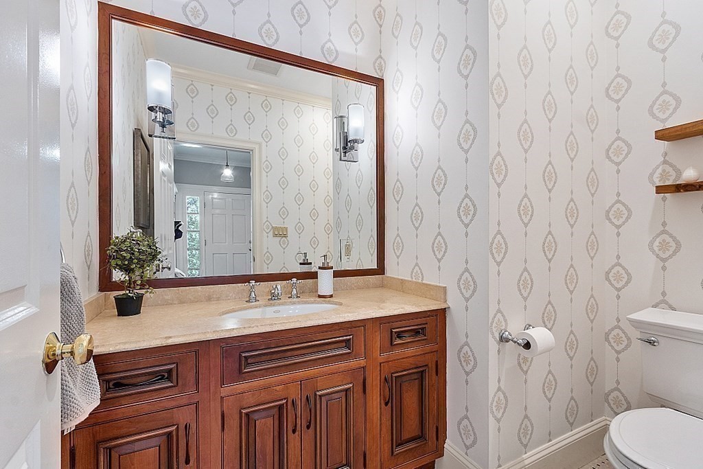 490 Lexington Road Concord, MA 01742 - Photo 17 of 40 a bathroom with a granite countertop sink a toilet and a mirror