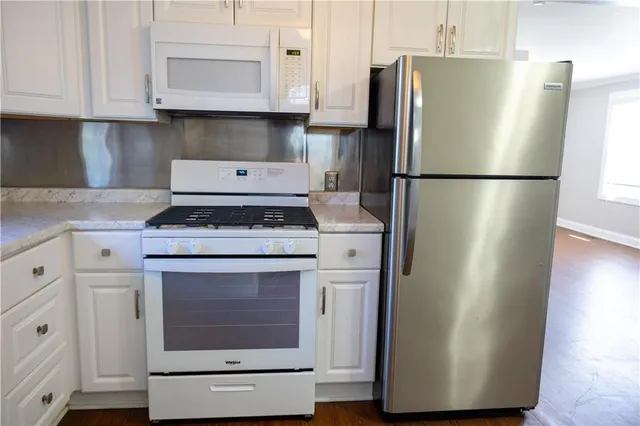 a kitchen with stainless steel appliances granite countertop a refrigerator sink and stove