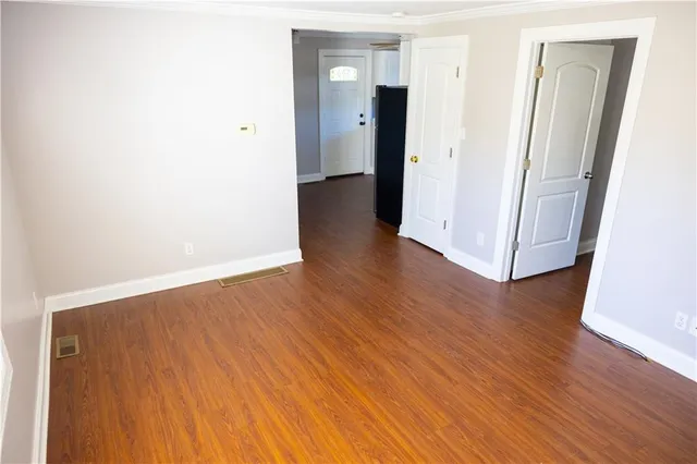 an empty room with wooden floor and a window