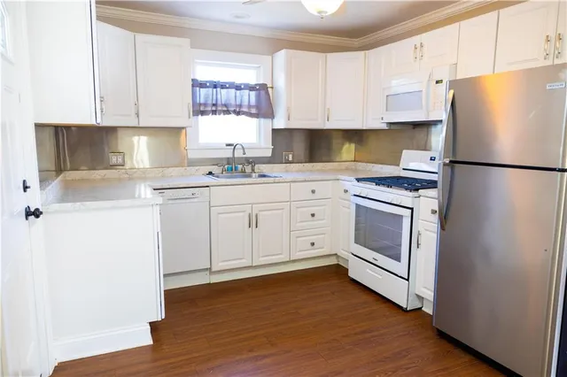 a kitchen with cabinets appliances a sink and a window