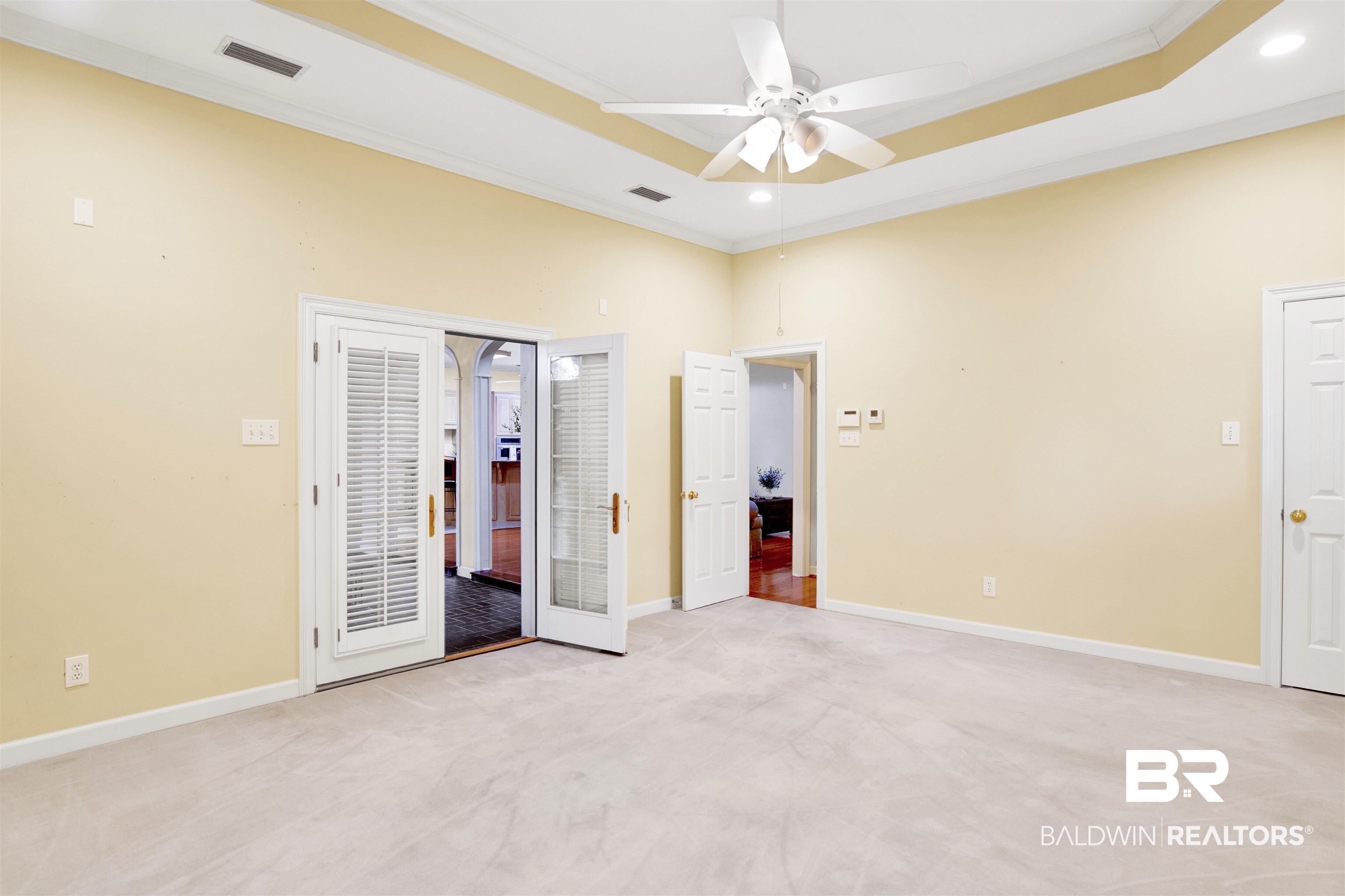 106 Old Mill Road Fairhope, AL 36532 - Photo 43 of 49 Unfurnished bedroom featuring a tray ceiling, light colored carpet, ornamental molding, baseboards, and visible vents