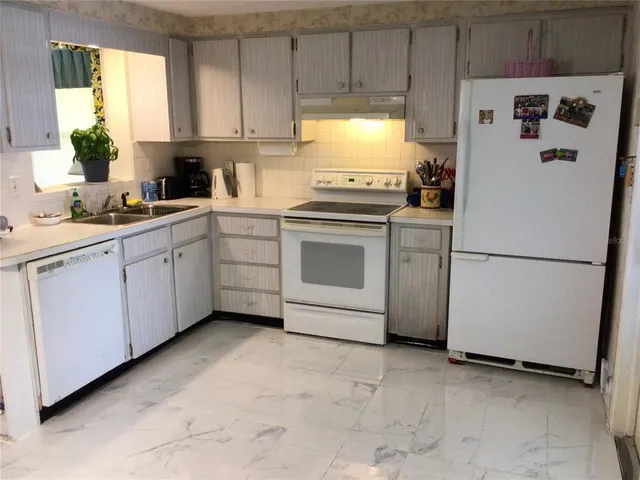 a kitchen with a refrigerator sink and cabinets