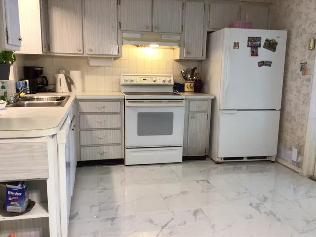 a white refrigerator freezer sitting in a kitchen