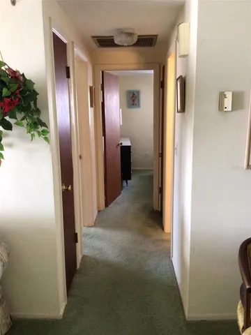 a view of a hallway with wooden shelves