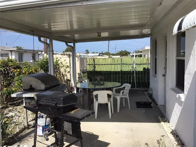 a view of a patio with table and chairs under an umbrella