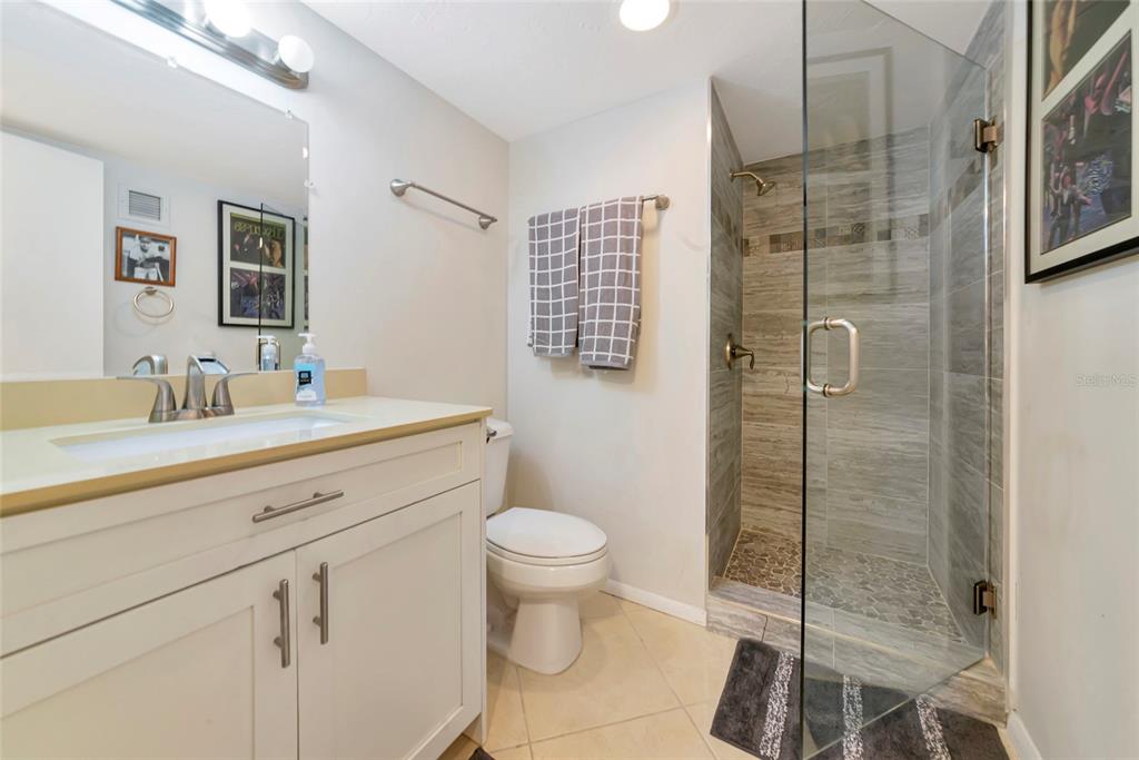 101 South Gulfstream Avenue, Unit 16C Sarasota, FL 34236 - Photo 13 of 86 a bathroom with a shower sink vanity mirror and toilet