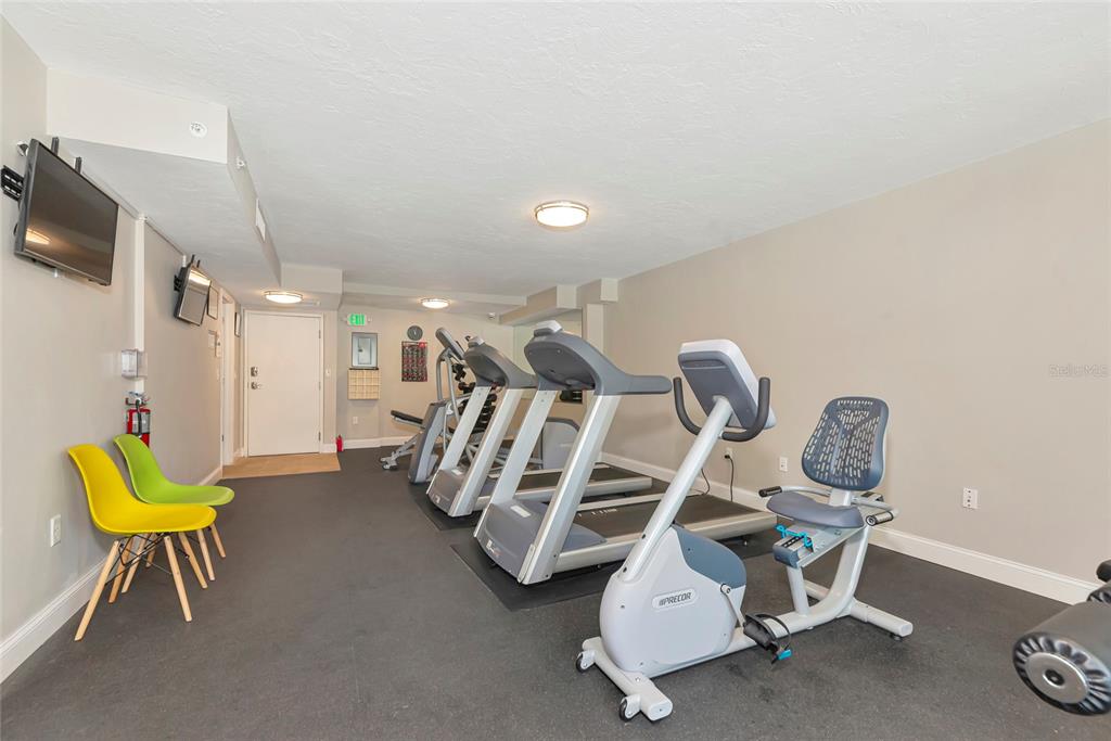 101 South Gulfstream Avenue, Unit 16C Sarasota, FL 34236 - Photo 18 of 86 a room with gym equipment and wooden floor