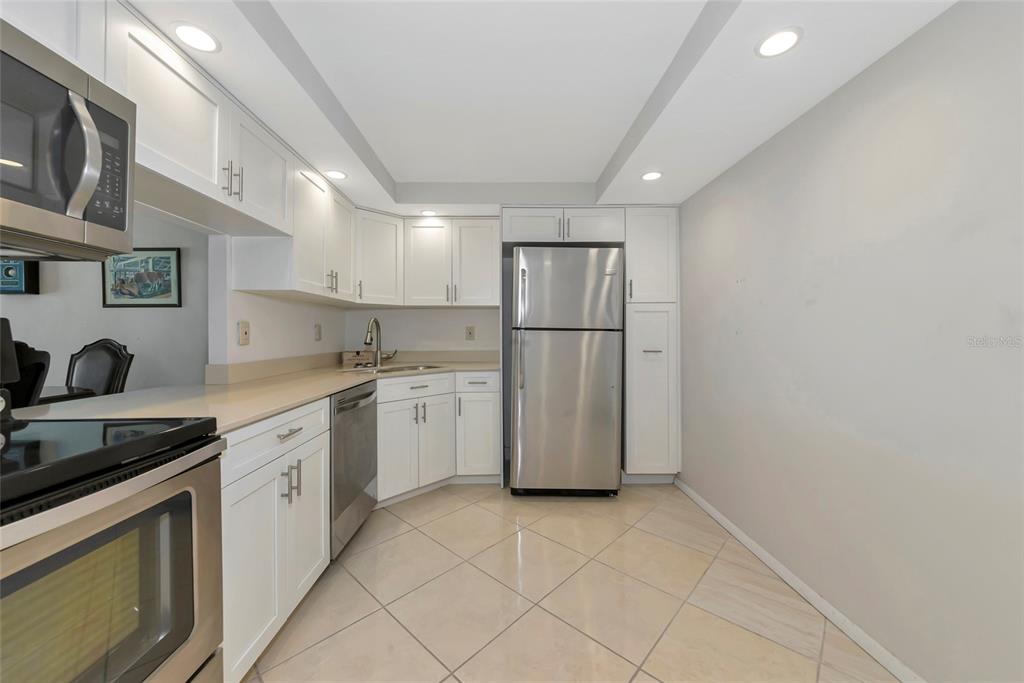101 South Gulfstream Avenue, Unit 16C Sarasota, FL 34236 - Photo 37 of 86 a kitchen with a sink a refrigerator and cabinets