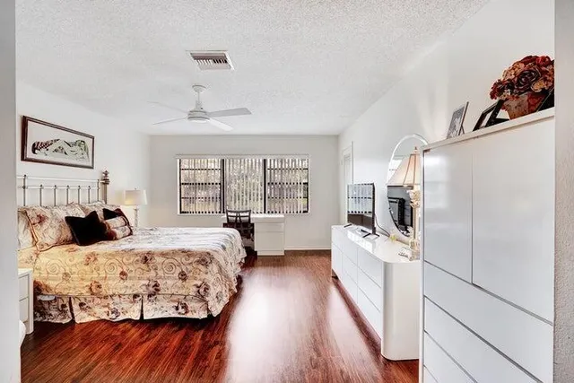 a bedroom with a bed a flat screen tv and a couch