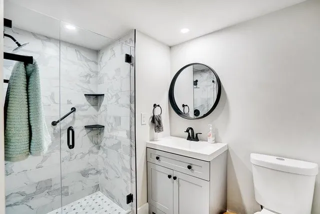 a bathroom with a sink mirror toilet and a shower