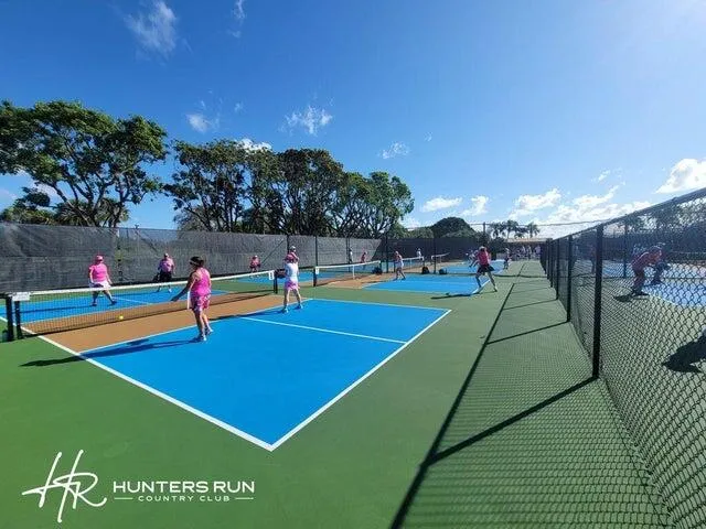 a view of a tennis ground with large trees