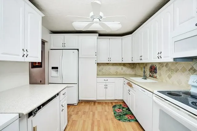 a kitchen with white cabinets sink and white appliances