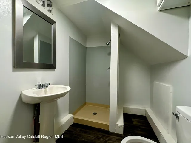 a bathroom with a sink a toilet and shower