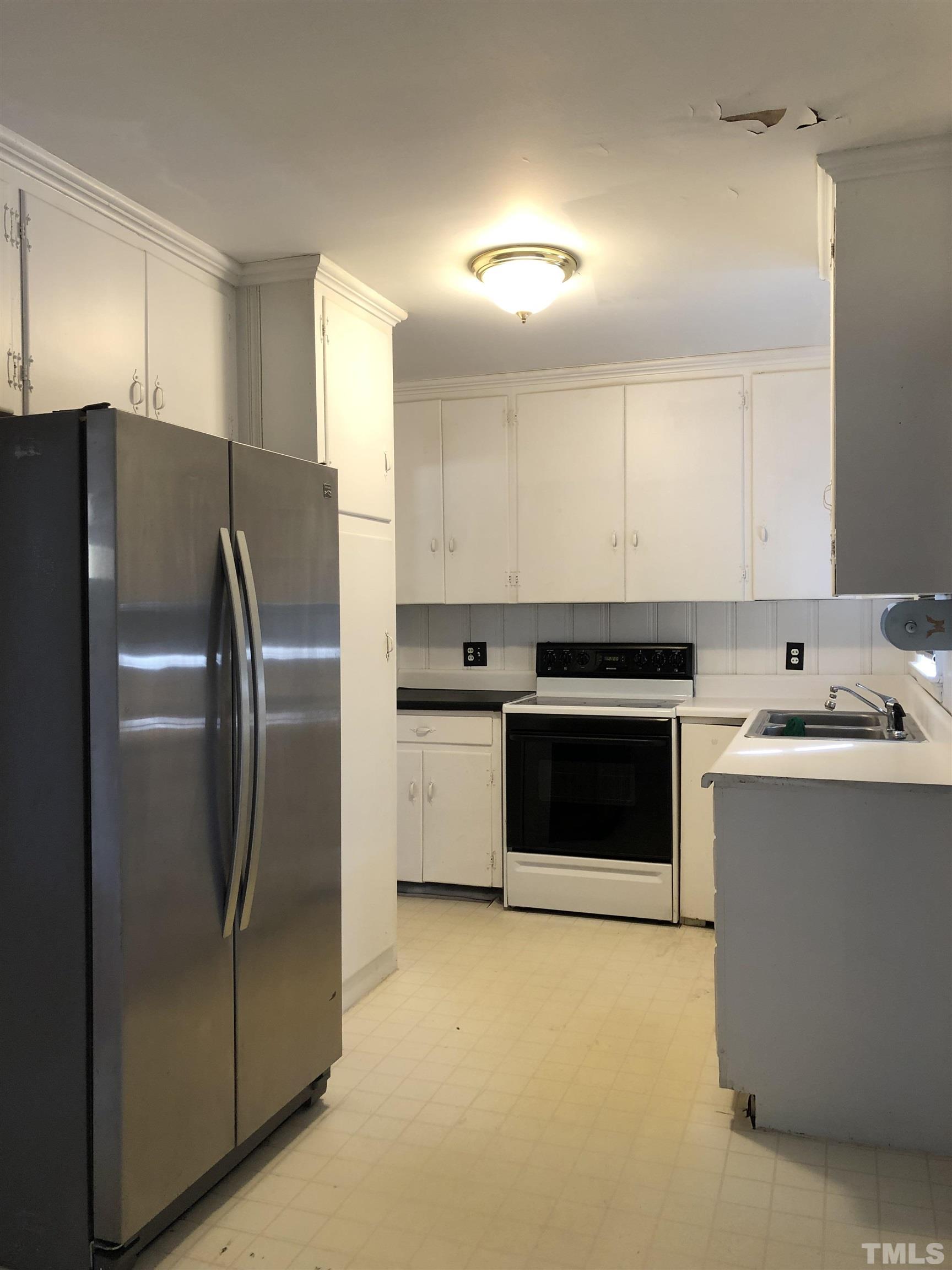 1402 Southerlund Road Garner, NC 27529 - Photo 5 of 18 a kitchen with a refrigerator sink and cabinets