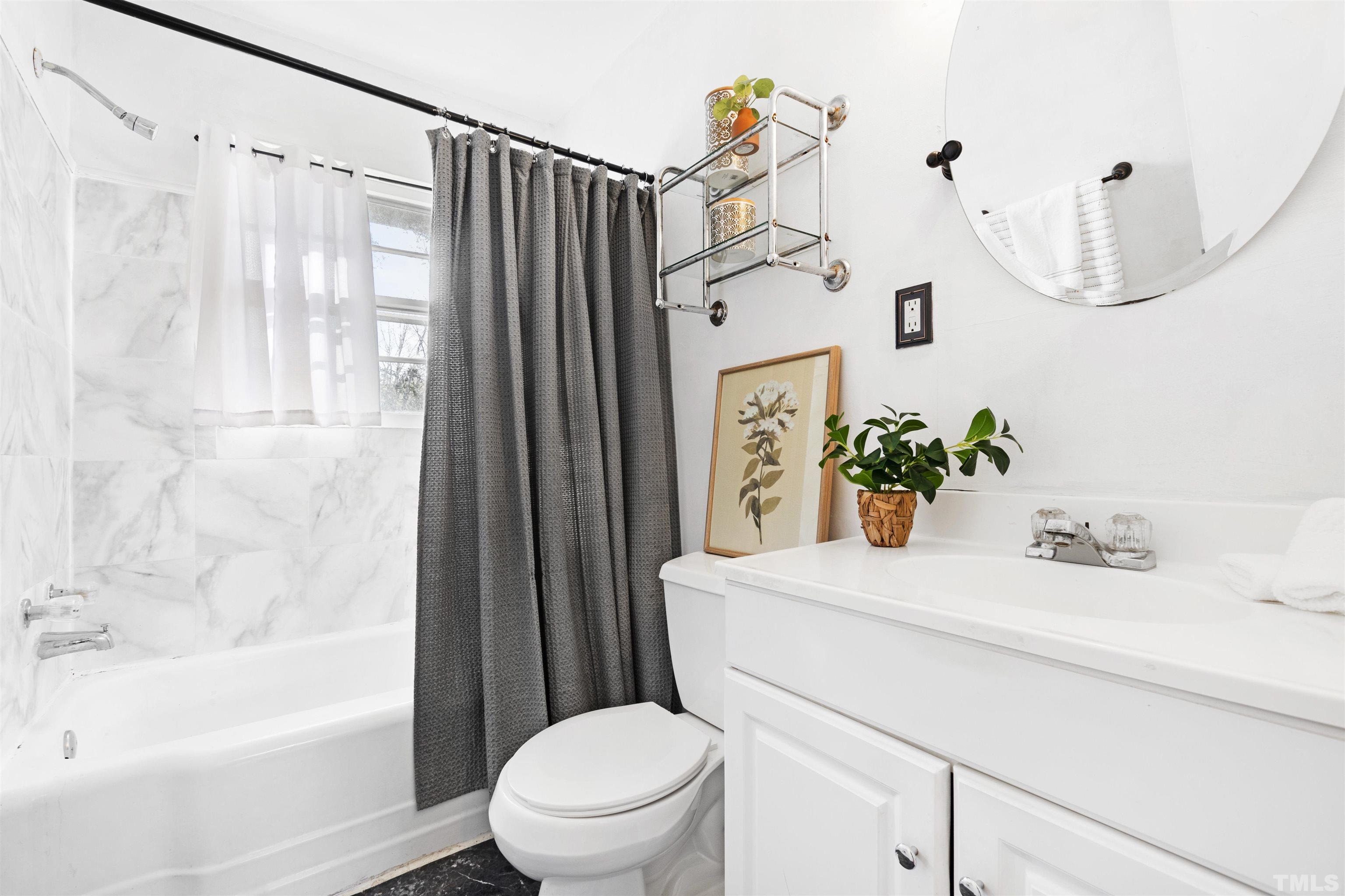 1402 Southerlund Road Garner, NC 27529 - Photo 8 of 18 a bathroom with a sink a toilet and tub
