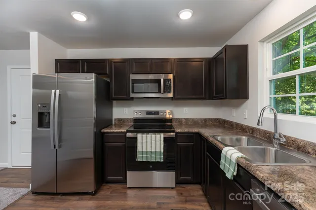 a kitchen with granite countertop a refrigerator and a sink