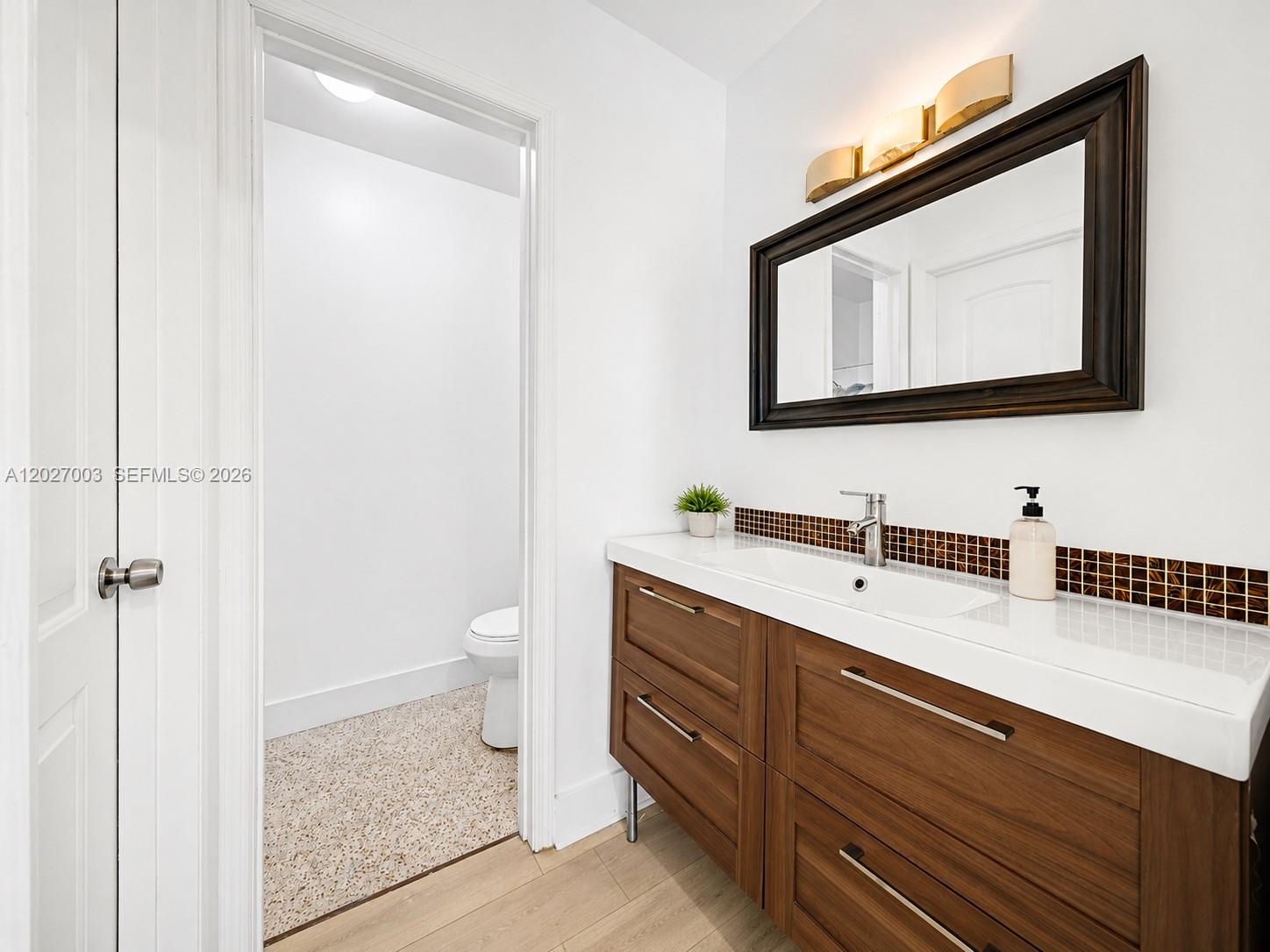 2761 Southwest 92nd Place Miami, FL 33165 - Photo 35 of 37 a bathroom with a toilet sink and mirror