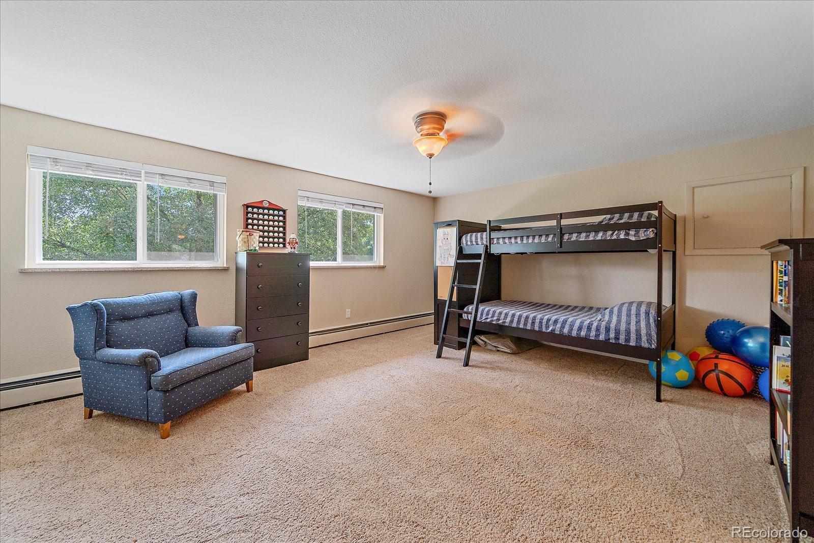 930 Reed Court Lakewood, CO 80214 - Photo 29 of 41 a bedroom with furniture and a chair