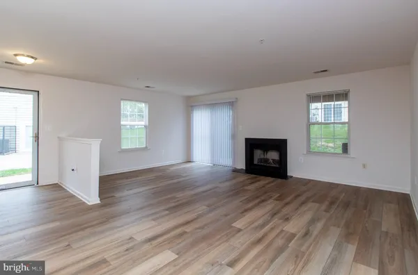 an empty room with wooden floor and fireplace