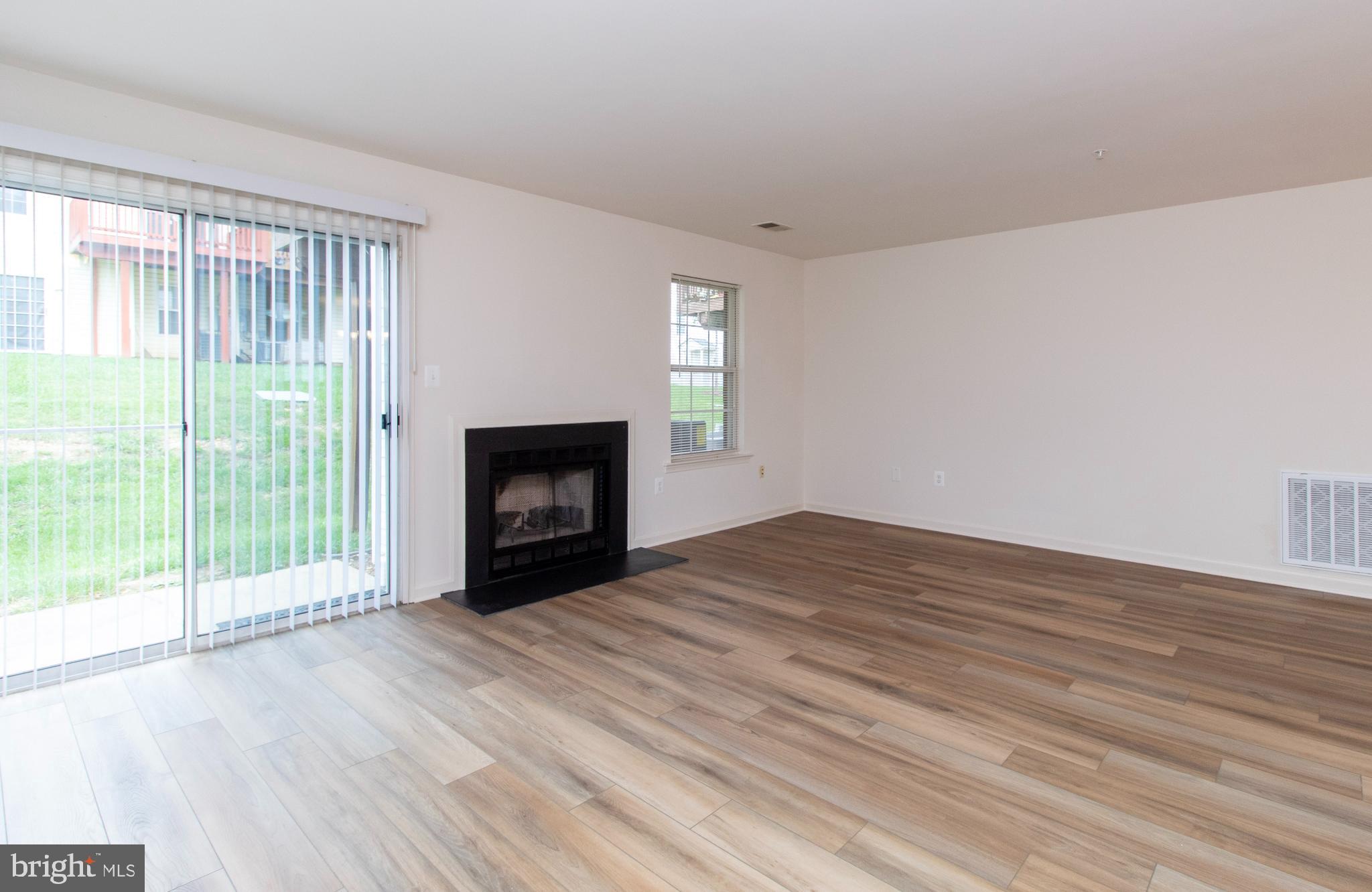 4145 Apple Orchard Court, Unit 1 Suitland, MD 20746 - Photo 4 of 16 a view of empty room with wooden floor and fireplace