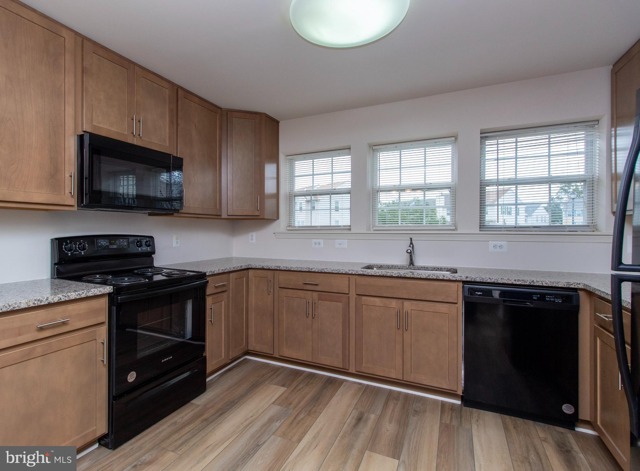 4145 Apple Orchard Court, Unit 1 Suitland, MD 20746 - Photo 6 of 16 a kitchen with stainless steel appliances a stove sink microwave and cabinets