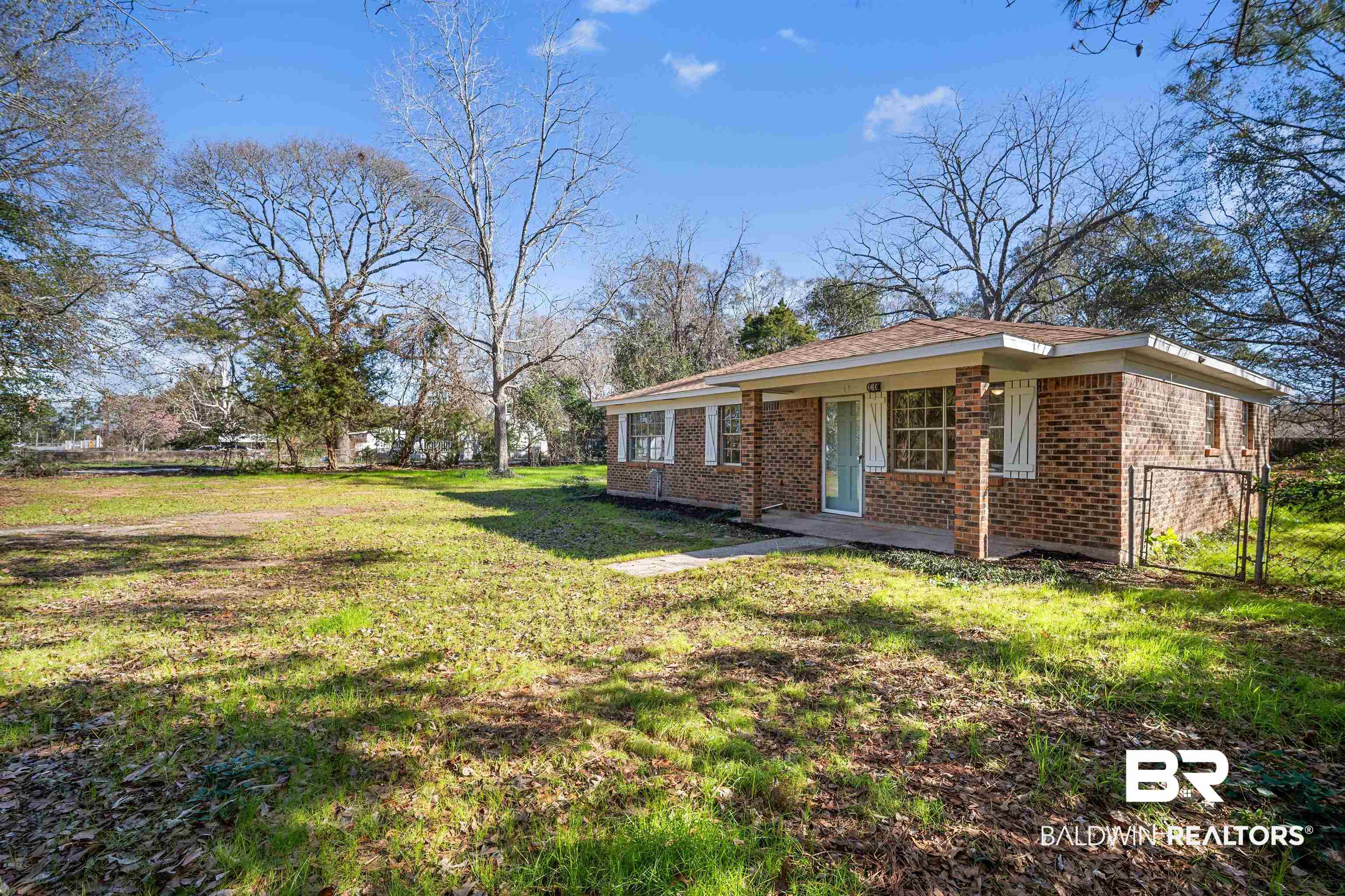 1368 Hubert Pierce Road Mobile, AL 36608 - Photo 2 of 25 View of front of home featuring a front yard, brick siding, and a gate