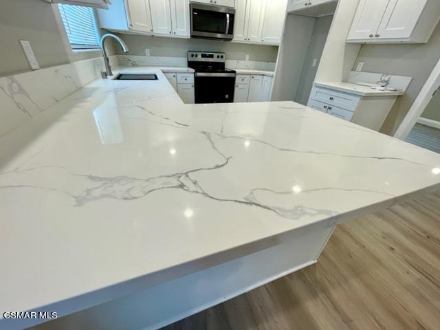 1243 Able Circle Simi Valley, CA 93065 - Photo 3 of 10 a kitchen with a sink a stove and a microwave oven