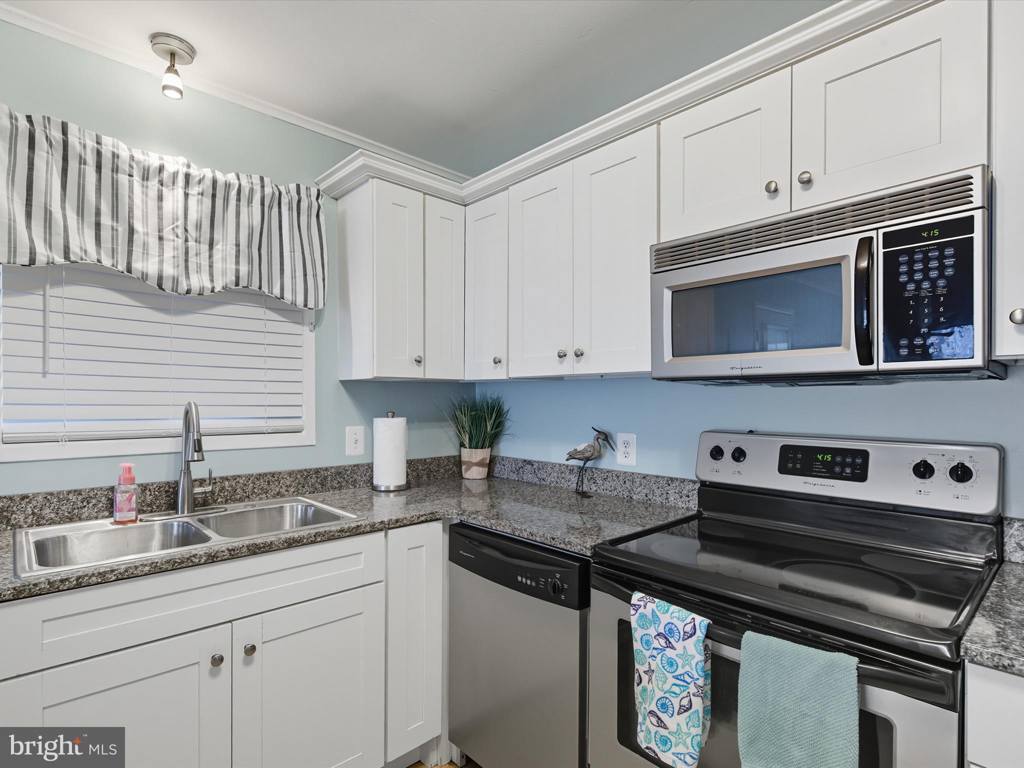 710 Bradley Road, Unit A2 Ocean City, MD 21842 - Photo 12 of 40 a kitchen with stainless steel appliances granite countertop a sink stove and cabinets