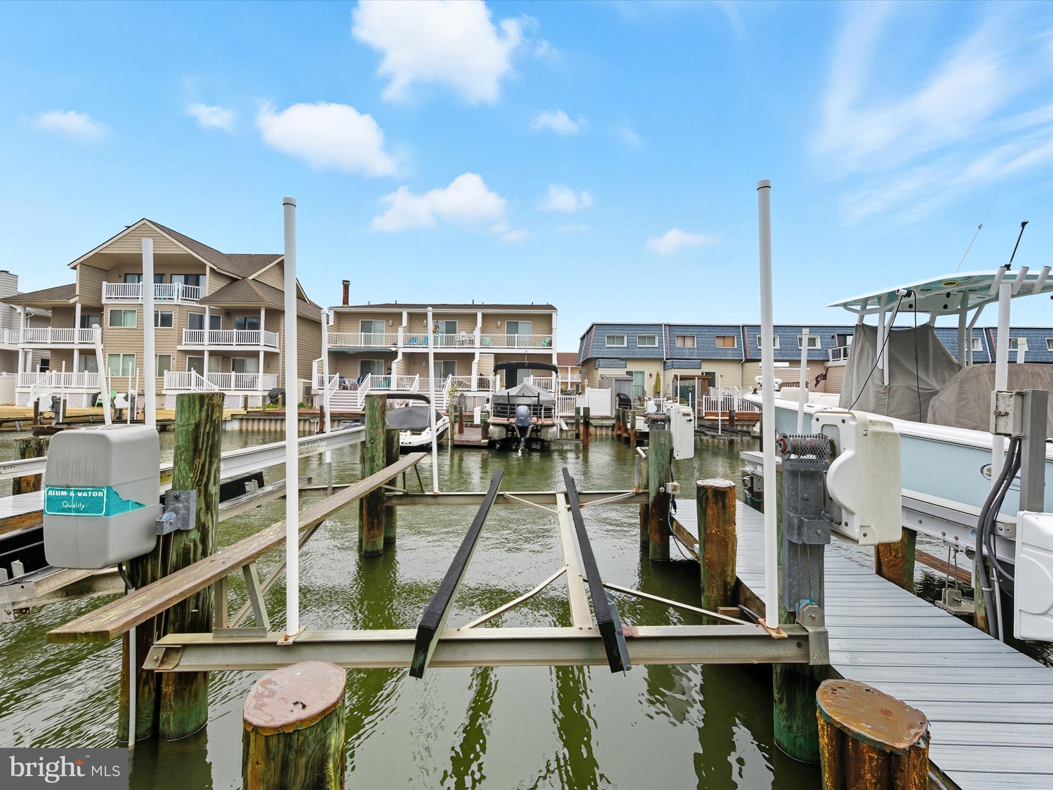 710 Bradley Road, Unit A2 Ocean City, MD 21842 - Photo 35 of 40 a view of a lake with a large pool and lawn chairs