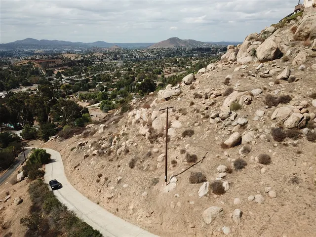 a view of a dry yard with wooden fence