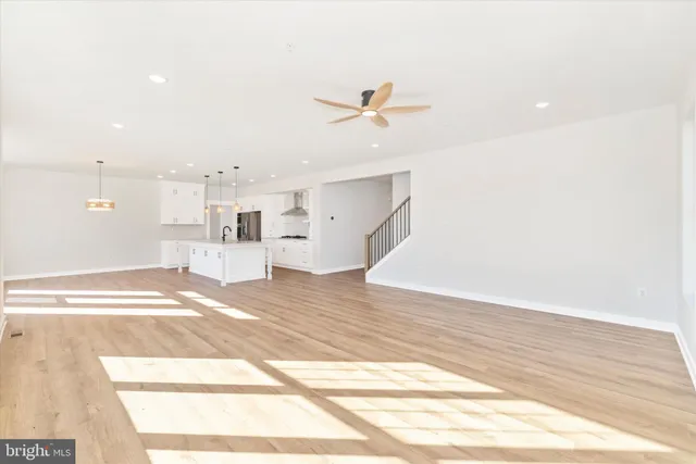 a view of a room with wooden floor and ceiling fan