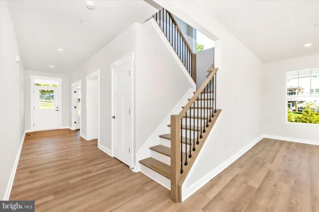 a view of a hallway with wooden floor and staircase