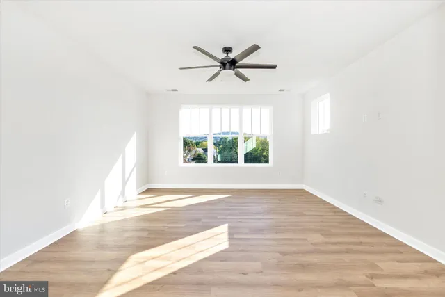 a view of a livingroom with a ceiling fan and window