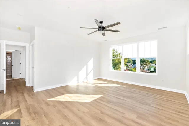 a view of a livingroom with wooden floor and a window