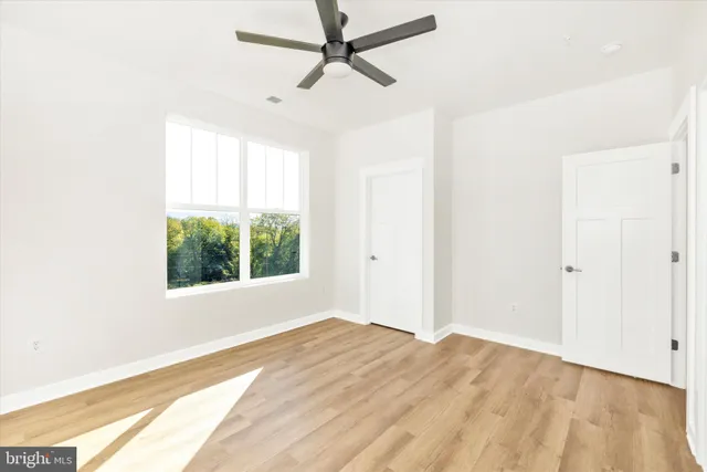 a view of a bedroom with a window and a ceiling fan