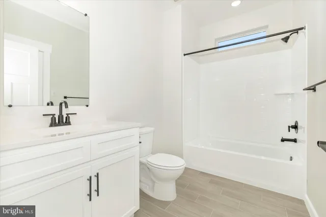 a bathroom with a bathtub shower sink vanity and toilet