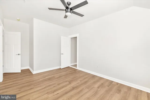 a view of room with wooden floor and ceiling fan